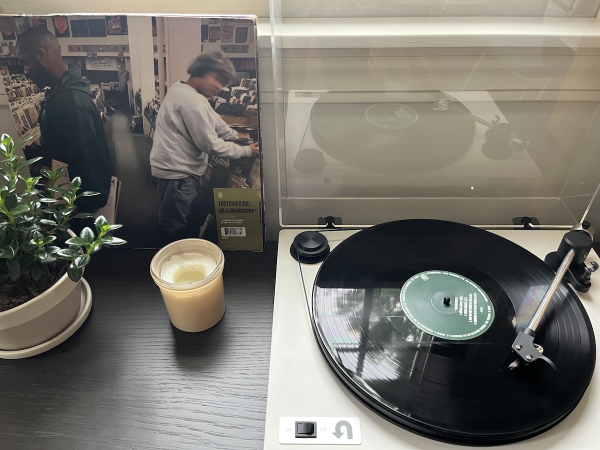 A picture of a turntable playing DJ Shadow's Endtroducing... album. The record sleeve is sitting next to the record player.